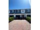 Street view of townhomes with brick driveways, attached garages, and colorful plants at 2883 Narcoossee Commons Way, St Cloud, FL 34771