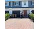 Charming townhome featuring a brick-paved driveway and an attached one-car garage at 2883 Narcoossee Commons Way, St Cloud, FL 34771