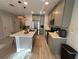 Well-lit kitchen featuring stainless steel appliances, island with seating, and gray cabinets at 2883 Narcoossee Commons Way, St Cloud, FL 34771
