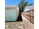 Side yard with green and brown grass, wooden fence, and AC unit along the exterior wall at 3208 Timberline Road, Winter Haven, FL 33880
