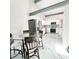 Open-concept dining area with adjacent kitchen, featuring a glass-top table and sleek design at 3208 Timberline Road, Winter Haven, FL 33880