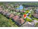Aerial view of home in residential area near lake, neighborhood streets, and surrounded by lush trees at 343 Scripps Ranch Rd, Poinciana, FL 34759