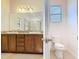 Bathroom featuring double sink vanity with granite countertops, toilet and natural lighting through the window at 343 Scripps Ranch Rd, Poinciana, FL 34759