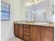 Bright bathroom featuring double sink vanity with granite countertops and natural lighting through the window at 343 Scripps Ranch Rd, Poinciana, FL 34759