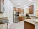 Bright kitchen features granite countertops, stainless steel appliances, and wood cabinets at 343 Scripps Ranch Rd, Poinciana, FL 34759