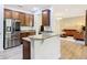 Open concept kitchen with granite countertops, stainless steel refrigerator, and views into the living room at 343 Scripps Ranch Rd, Poinciana, FL 34759
