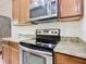 Modern kitchen with stainless steel oven, microwave, and granite countertops at 343 Scripps Ranch Rd, Poinciana, FL 34759