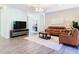 Inviting living room featuring a TV, comfortable seating, and hardwood floors at 343 Scripps Ranch Rd, Poinciana, FL 34759