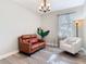 Living room featuring hardwood floors, a brown leather loveseat, and a white armchair at 343 Scripps Ranch Rd, Poinciana, FL 34759