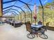 Spacious screened-in patio with dining table and multiple seating areas at 343 Scripps Ranch Rd, Poinciana, FL 34759