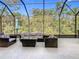 Enclosed patio with seating, table, and views of lush greenery at 343 Scripps Ranch Rd, Poinciana, FL 34759