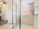 Tiled walk-in shower with glass door and safety bar at 343 Scripps Ranch Rd, Poinciana, FL 34759