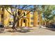 Bright yellow three-story apartment building featuring mature shade trees and on-site parking at 4528 Commander Dr # 2013, Orlando, FL 32822