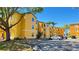 Bright yellow three-story apartment building featuring on-site parking and mature shade trees at 4528 Commander Dr # 2013, Orlando, FL 32822