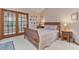 Cozy bedroom with a wooden sleigh bed, charming decor, and access to a sunroom through glass doors at 508 Alcazar Ct, The Villages, FL 32159