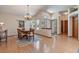 Open dining room area with elegant chandelier, wood floors, and views of front yard at 508 Alcazar Ct, The Villages, FL 32159