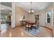 Spacious dining room with chandelier, wood floors, table for six, and lots of light at 508 Alcazar Ct, The Villages, FL 32159