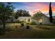 Beautifully landscaped single-story home with a well-maintained lawn under a picturesque sunset sky at 508 Alcazar Ct, The Villages, FL 32159
