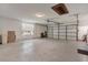 Spacious garage with a large garage door, a window with curtains, and epoxy flooring at 508 Alcazar Ct, The Villages, FL 32159