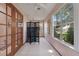 Bright hallway featuring a decorative screen, large windows, and elegant glass panel doors at 508 Alcazar Ct, The Villages, FL 32159