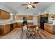 Spacious eat-in kitchen with wood cabinetry, granite countertops, black appliances, and wood-look flooring at 508 Alcazar Ct, The Villages, FL 32159