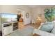 Cozy living room with a decorative rug, entertainment center, and a glimpse into the adjacent kitchen at 508 Alcazar Ct, The Villages, FL 32159