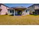 Exterior view of the backyard with a covered patio and green grass at 5118 Tiber Way, St Cloud, FL 34771