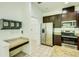 Bright kitchen with stainless steel appliances and granite countertops, adjacent to laundry room at 5118 Tiber Way, St Cloud, FL 34771