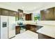 Well-lit kitchen features dark wood cabinets, granite countertops, and stainless steel appliances at 5118 Tiber Way, St Cloud, FL 34771