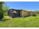 View of a backyard with a screened lanai and well-maintained lawn at 523 Shell Creek St, Poinciana, FL 34759