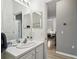 Clean bathroom with white vanity, mirror, and view into an adjacent living space at 523 Shell Creek St, Poinciana, FL 34759