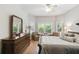 Bright bedroom with large windows, seating area, and wood dresser with a large mirror at 523 Shell Creek St, Poinciana, FL 34759