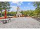 Outdoor lounge area features a stone fireplace, seating, and lush landscaping for relaxing and entertaining at 523 Shell Creek St, Poinciana, FL 34759
