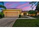 Inviting single-story home with a manicured lawn, landscaped garden, and a two-car garage at 523 Shell Creek St, Poinciana, FL 34759