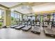 A fully-equipped gym features modern treadmills and floor to ceiling windows at 523 Shell Creek St, Poinciana, FL 34759
