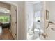 Bright powder room featuring toilet, tile flooring, and adjacent bedroom with hardwood flooring at 523 Shell Creek St, Poinciana, FL 34759