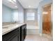 Bright bathroom featuring double vanity, soaking tub, and walk-in shower at 53 Zinnia E Ln, Kissimmee, FL 34759