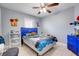 This bedroom features a tiled floor, a ceiling fan, and a blue accent wall at 53 Zinnia E Ln, Kissimmee, FL 34759