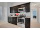 Stylish kitchen featuring granite countertops, modern appliances, and ample dark cabinetry at 53 Zinnia E Ln, Kissimmee, FL 34759