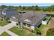 Beautiful aerial view of a home with a manicured lawn, mature landscaping, and a nearby canal at 5759 Marsh Landing Dr, Winter Haven, FL 33881