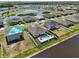Expansive aerial view of a residential community with a lake, showcasing modern homes with manicured lawns at 5759 Marsh Landing Dr, Winter Haven, FL 33881