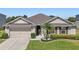 Charming single-story home featuring a well-manicured lawn, two car garage, and neutral colored stucco at 5759 Marsh Landing Dr, Winter Haven, FL 33881