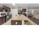 Bright kitchen featuring dark cabinets, a spacious island with bar seating, and modern appliances at 5759 Marsh Landing Dr, Winter Haven, FL 33881