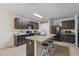 Spacious kitchen with dark cabinets, an island with seating, and neutral tile flooring at 5759 Marsh Landing Dr, Winter Haven, FL 33881
