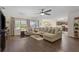 Open-concept living room featuring a large sectional sofa, wood floors, and abundant natural light at 5759 Marsh Landing Dr, Winter Haven, FL 33881
