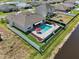 Aerial view of a backyard with a sparkling pool, patio area, and well-maintained landscaping with fencing at 5759 Marsh Landing Dr, Winter Haven, FL 33881