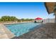 A refreshing backyard pool with a red umbrella and comfortable lounge chairs surrounded by lush landscaping at 5759 Marsh Landing Dr, Winter Haven, FL 33881