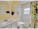 A full bathroom featuring a lemon shower curtain, white cabinet, and tiled bath at 577 Eagle Pointe S, Kissimmee, FL 34746