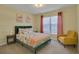 Cozy bedroom with a colorful bedspread, flamingo artwork, and a comfortable yellow chair at 577 Eagle Pointe S, Kissimmee, FL 34746