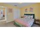 Bedroom with a colorful bedspread, flamingo artwork and dual closets at 577 Eagle Pointe S, Kissimmee, FL 34746